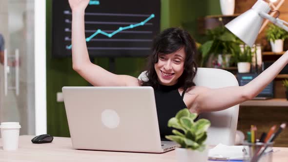 Excited Female Corporate Worker Reads Good News on the Laptop alt