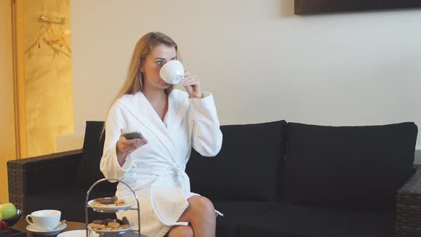Beautiful Young Girl Drinking Tea in Relaxation Room After Spa Treatments