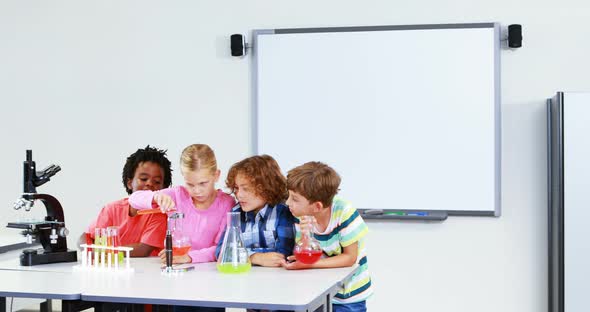 Kids doing a chemical experiment in laboratory alt