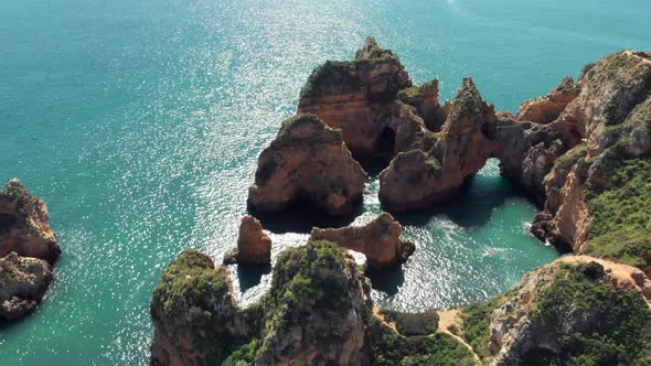Stone Arch 'Catedral' in Algarve Coastline in Lagos Portugal - Aerial Orbit slow tilt-up shot alt