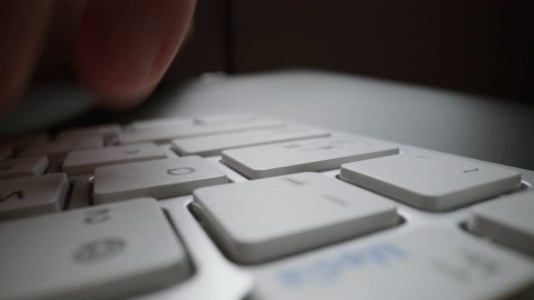Close-up typing on keyboard with man fingers. Macro soft focus dolly shot. alt