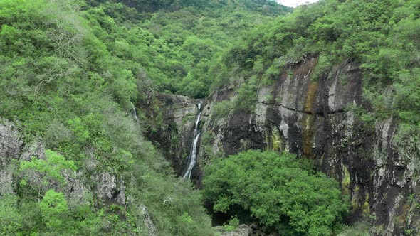 Camera is Flying Above Waterfall in Tropical Forest alt