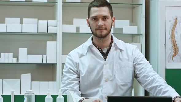 Portrait of young male pharmacist looking at camera and smiling