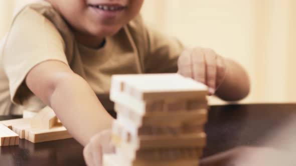 Laughing boy losing Jenga game