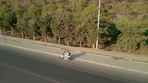 The Drone Follows a Motorcycle That Travels Along the Road Along the Sea Coast alt