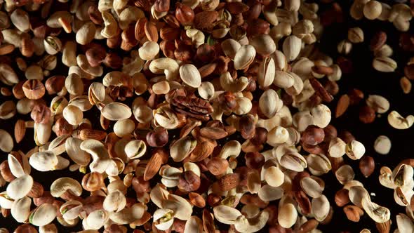 Super Slow Motion Shot of Flying Various Nuts Towards Camera Isolated on Black at 1000Fps alt