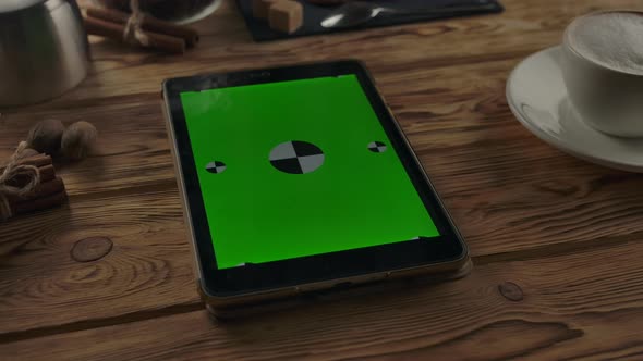 Vertical Green Screen Digital Pad on Wooden Table Near Coffee Cup on Wooden Table alt