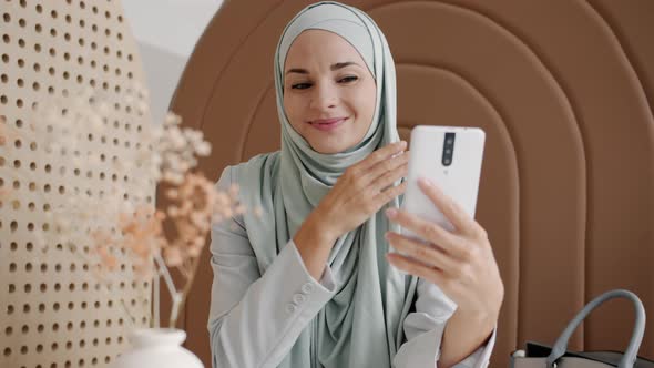 Happy Muslim Woman Using Smartphone to Take Selfies in Cafe Posing for Camera Smiling alt
