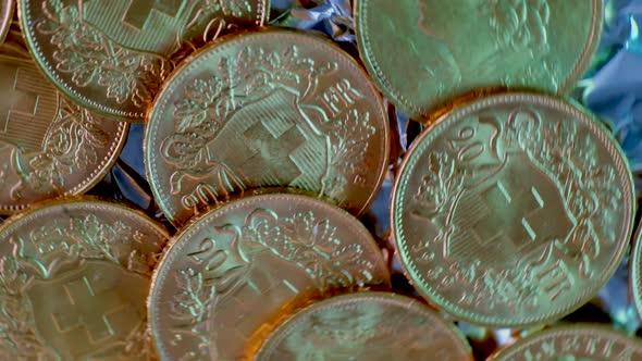 Close up spinning shot showing many rarely golden vreneli gold coins of swiss franc. alt