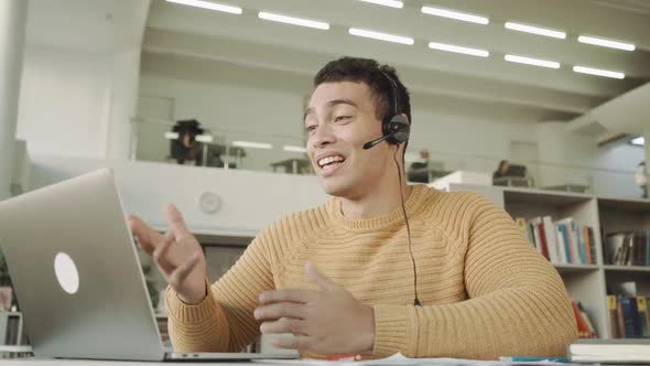 Smiling Employee in Headphones Using Laptop, Looking at Screen,mixed Race Man Making Video Call alt