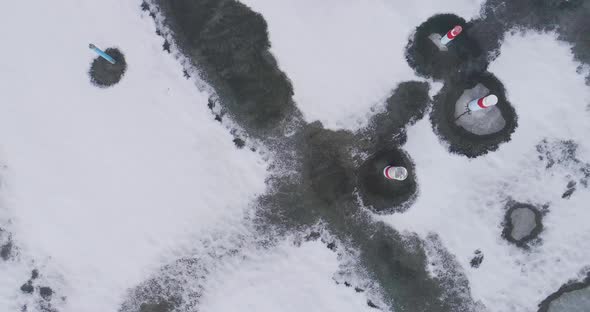 An empty concrete pad is stubbed out with utilities ready for a townhouse to be built.  Winter with alt