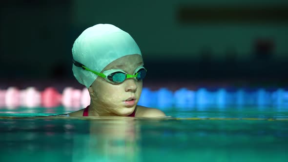 Portrait of Professional Teenager Girl Swimmer in Goggles Emerging From Swimming Pool alt