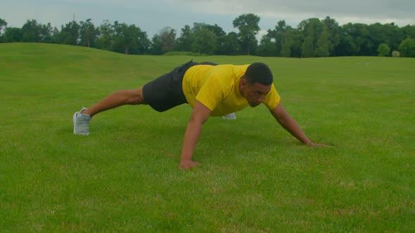 Muscular Build African American Man Stretching in Star Plank Position in Nature alt