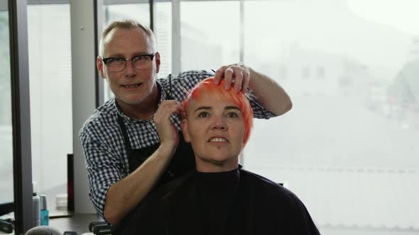Front view woman looking at her hair in the mirror alt
