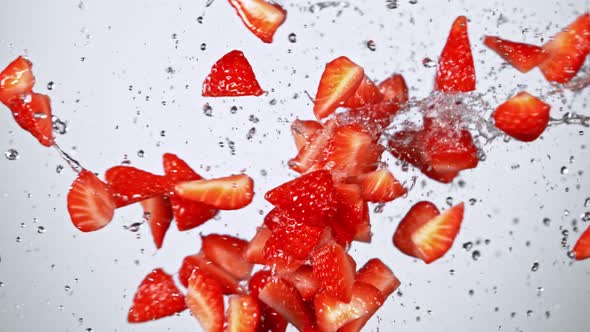 Super Slow Motion Shot of Fresh Strawberries and Water Side Collision on White at 1000Fps alt