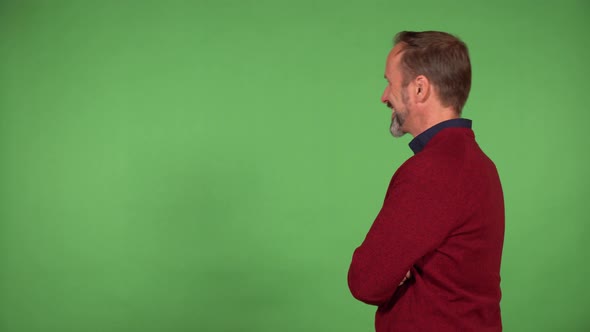 A Middleaged Handsome Caucasian Man Acts Happy and Talks in the Direction of the Green Screen