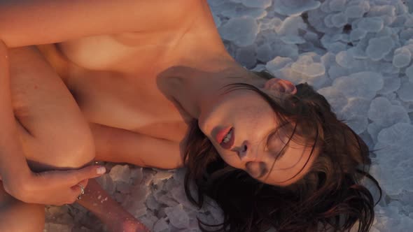 Attractive Soulful Nude Emotive Caucasian Female at a Salt Lake in Slow Motion alt