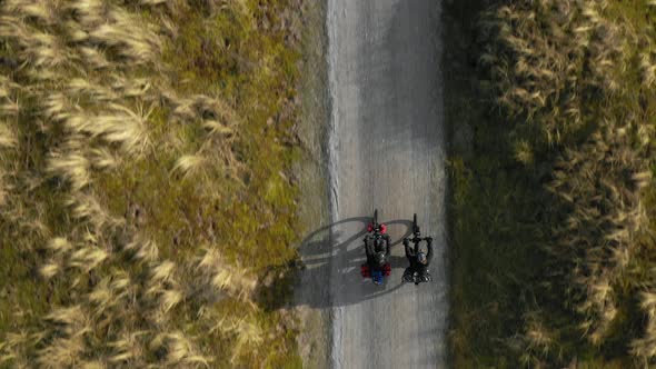 Man and woman riding bikes on dirt road, Nes, Friesland, Netherlands