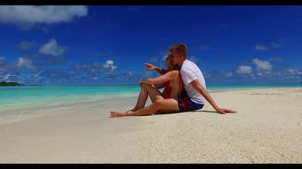 Family of two happy together on relaxing seashore beach wildlife by blue lagoon and bright sandy bac alt