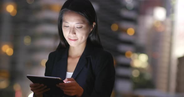 Young Businesswoman using tablet computer in city at night alt
