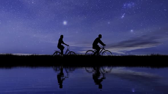 Two Cyclists On The Background Of Night Sky