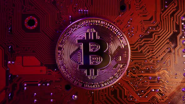 Golden coin with bitcoin symbol on electronic circuits in a computer mainboard. alt