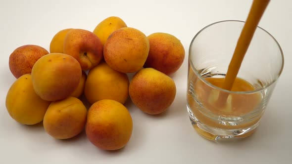 Fresh apricot juice is poured into a glass
