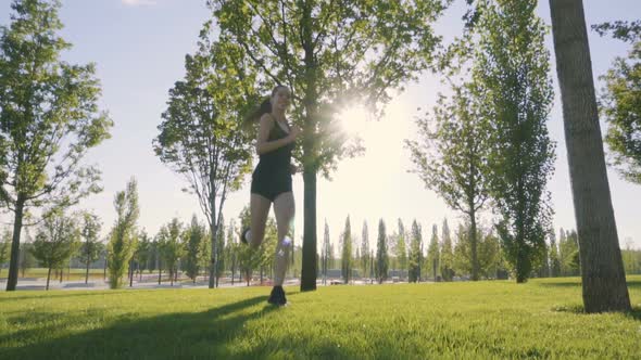 Sports Woman Makes Morning Jog and Physical Exercises In  Park alt