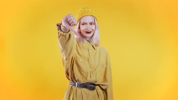 Young Pretty Woman Standing on Yellow Studio Background Expressing Discontent alt