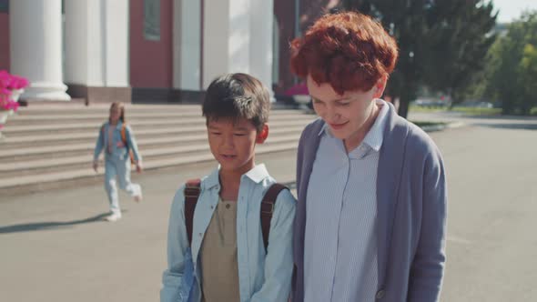 Woman Picking Schoolboy Up From School alt