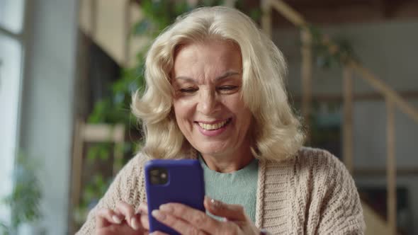 An Old Woman Looks at Photographs on the Phone alt