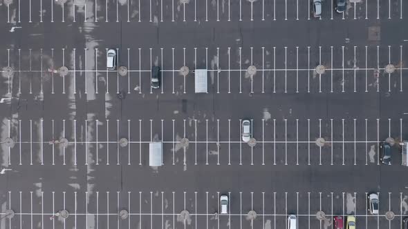 AERIAL: A Few Cars Parked in a Parking Space with Plenty of Empty Space 