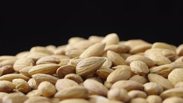 A Handful of Dried Almond Rotate on a Black Background alt