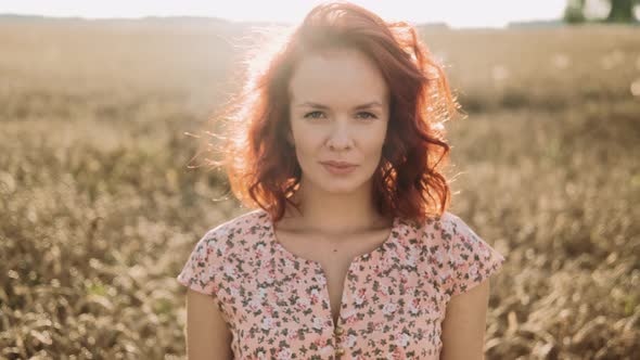 Portrait of Mysterious Ginger Woman is Enjoying Nature on Field alt