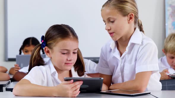 School kids using digital tablet in classroom alt