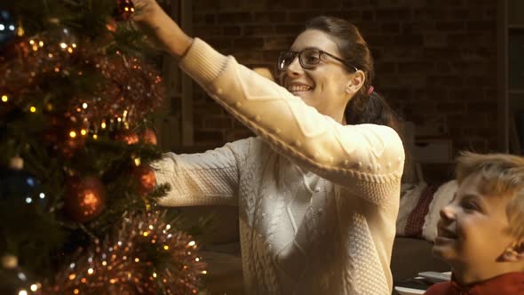 Young mother and boy decorating a Christmas tree