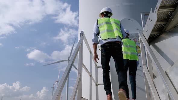 Two engineers are standing together discussing wind power projects