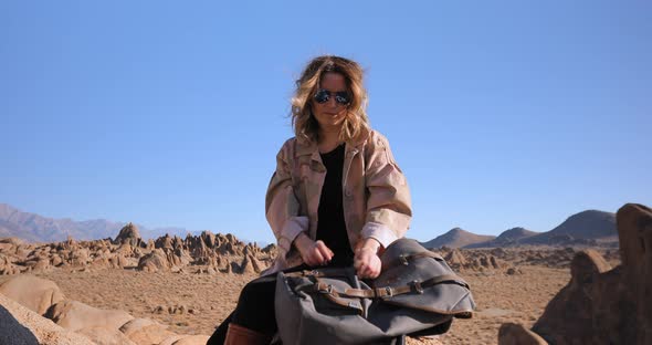 Attractive Young Woman Enjoying Sunrise in Rocky Nature Park on Sunny Day.  alt