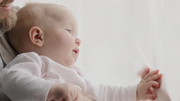 Caucasian Bearded Adult Father Holding Little Hand of Baby Near Window at Home Female Hands of alt