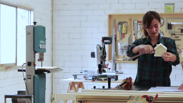 Two Carpenter workers designed in drawing paper for wood furniture project in workshop