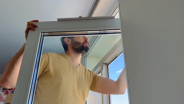Man Cleaning Window at Home Apartment
