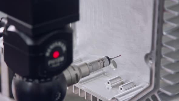 Macro footage of a coordinate measuring machine CMM measuring metal part alt