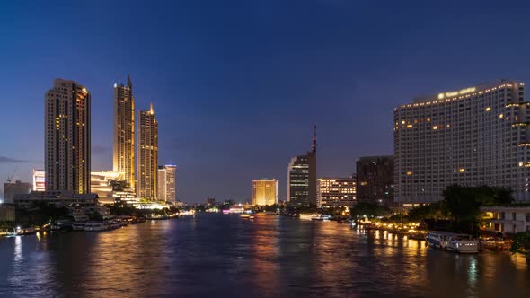 Bangkok waterfront cityscape and Chao Phraya River, day to night, zoom out - time lapse