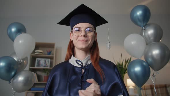 Charming Female Graduate in Academic Dress is Happily Video Chatting on Laptop During Online alt