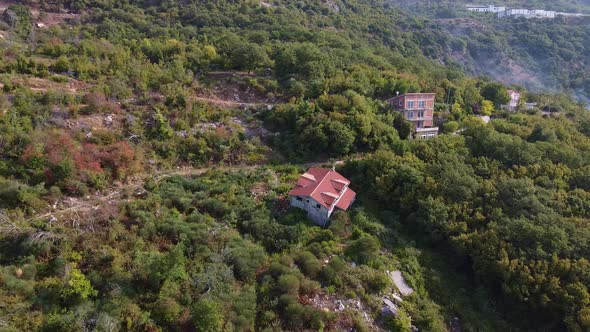 Aerial View of Ruined Building with Red Roof in the Mountain