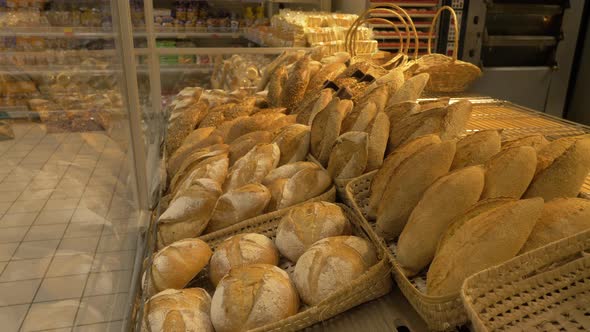 Pan left shot of breads on display in supermarket bakery alt