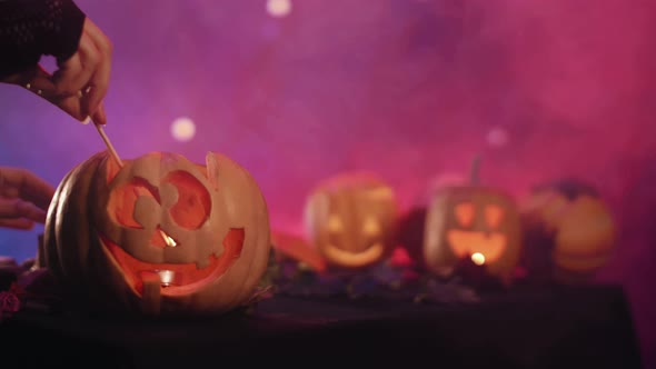 Witch lights pumpkin for halloween.  Set fire to pumpkin. Halloween!  4K.  Stock video.