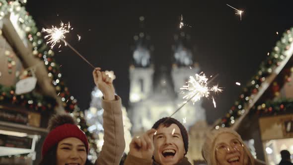 Pretty Young Friends Laughing and Dancing with Sparklers in the Street alt