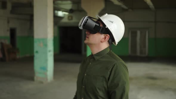 A Modern Engineer Wearing Virtual Reality Glasses Inspects a Construction Site