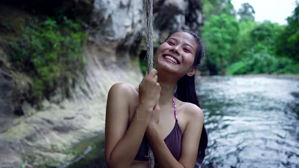 Cute Smiling Asian Girl in Bikini in the River By a Rope Thailand